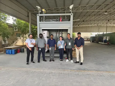Team standing in front of the completed grey portable fueling unit in the workshop yard
