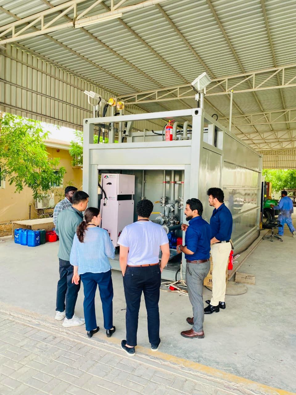 Visitors inspecting the portable fueling unit and its equipment bay